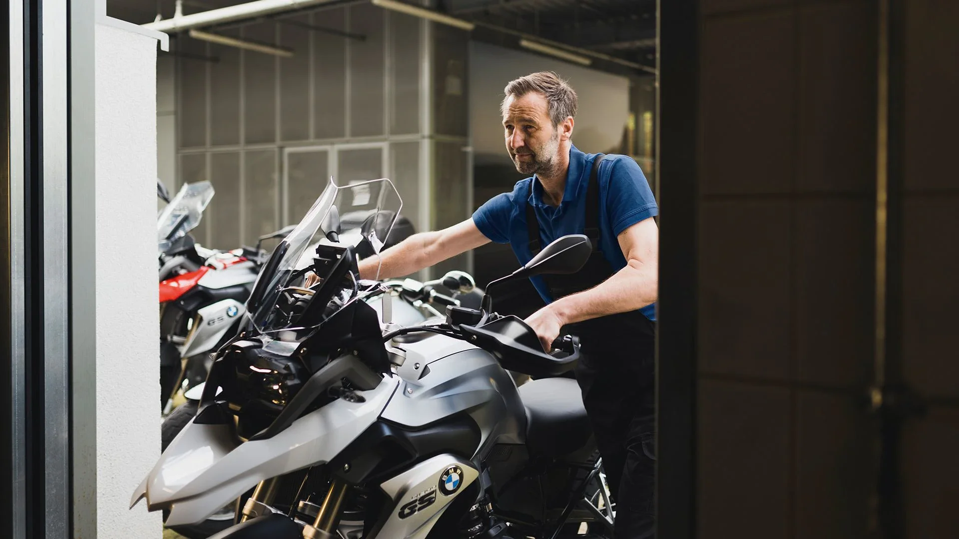 Team member preparing a BMW motorcycle for storage